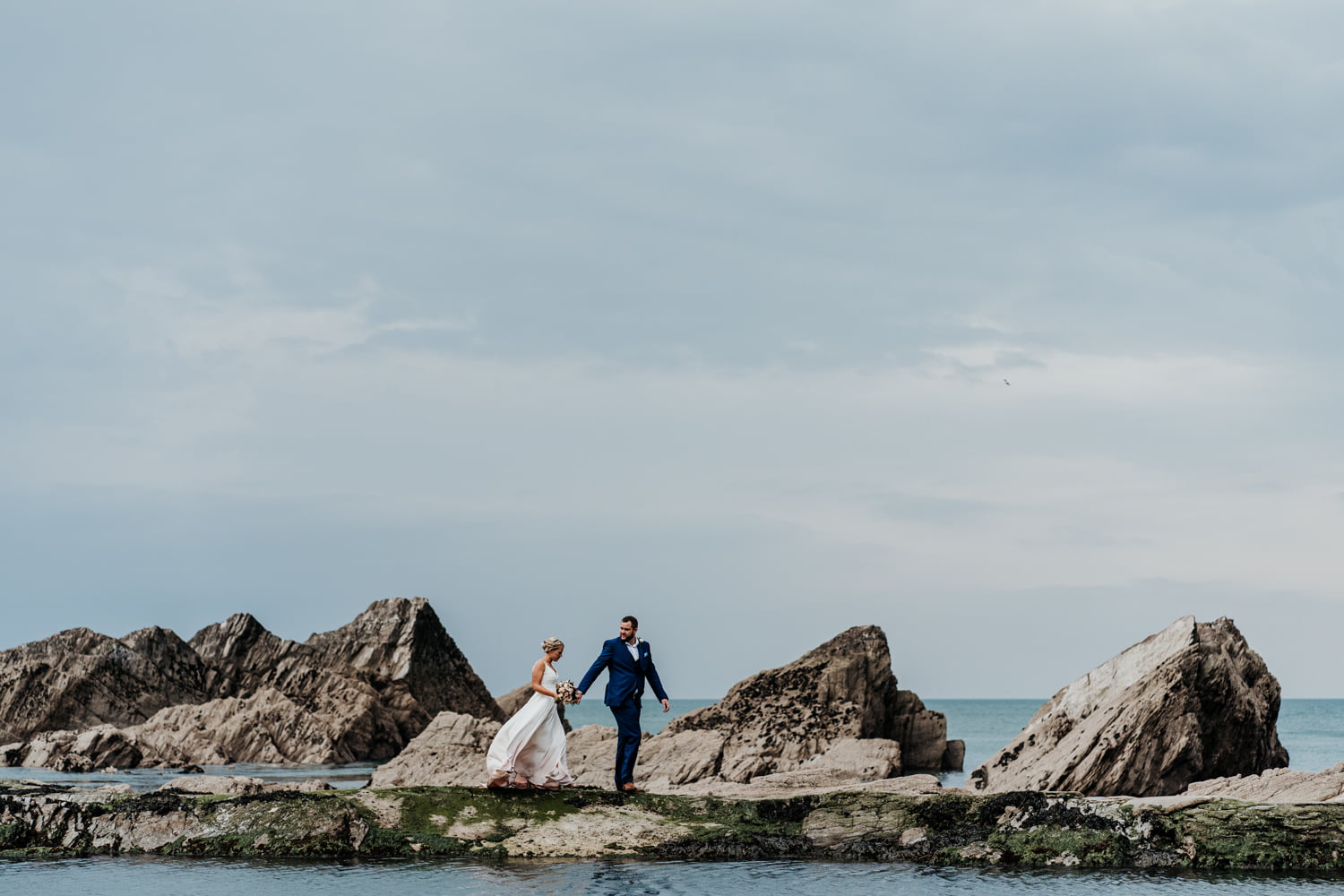 bride and groom on the tidal pool at tunnels beaches